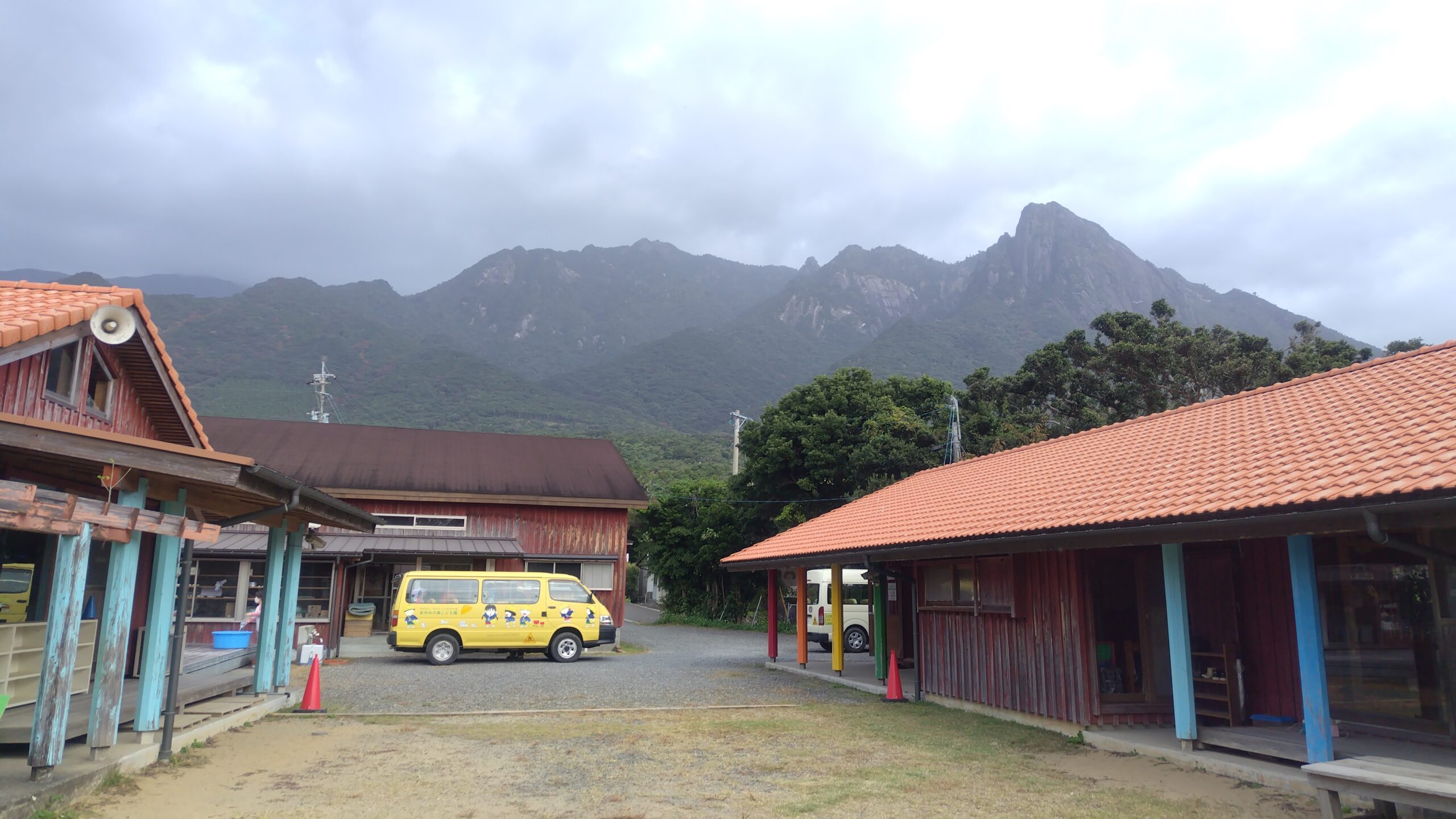 屋久島の山々を背景にしたあゆみの森こども園の園舎