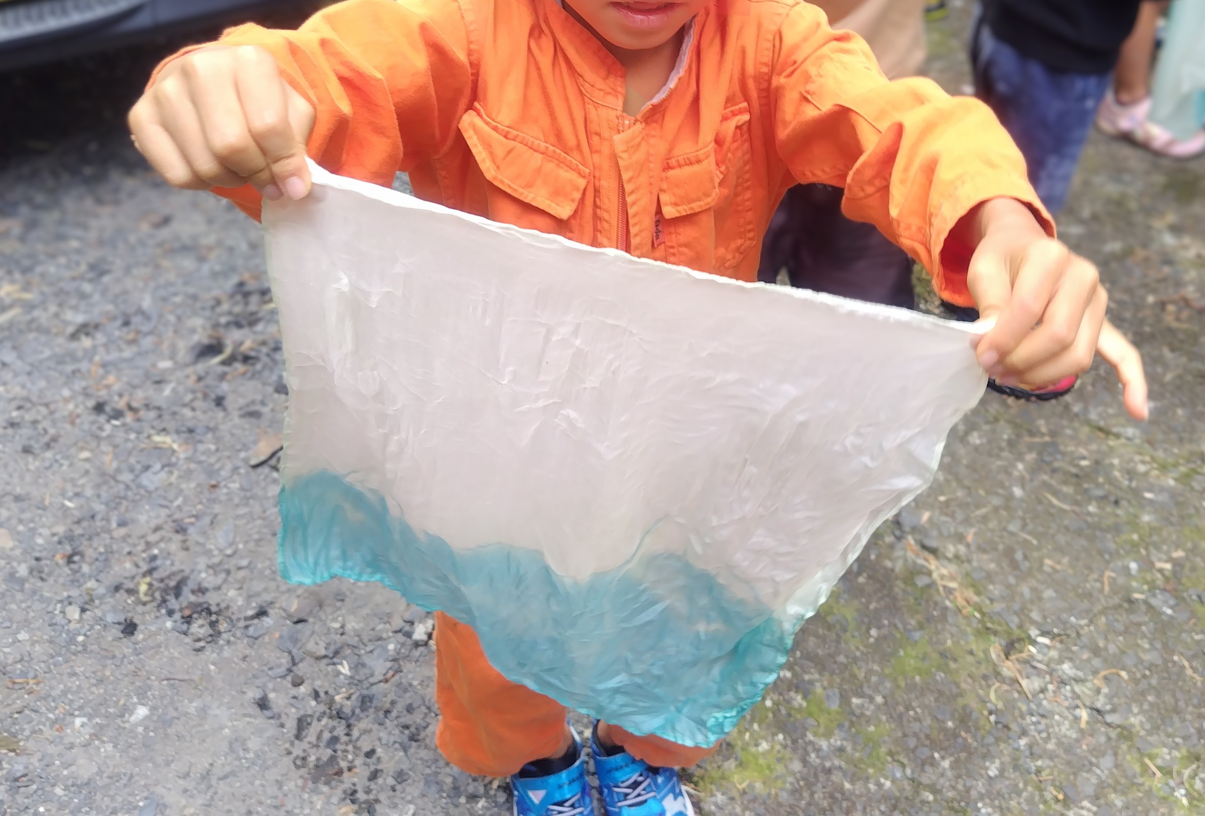 琉球藍で染めたハンカチを嬉しそうに見せる子ども