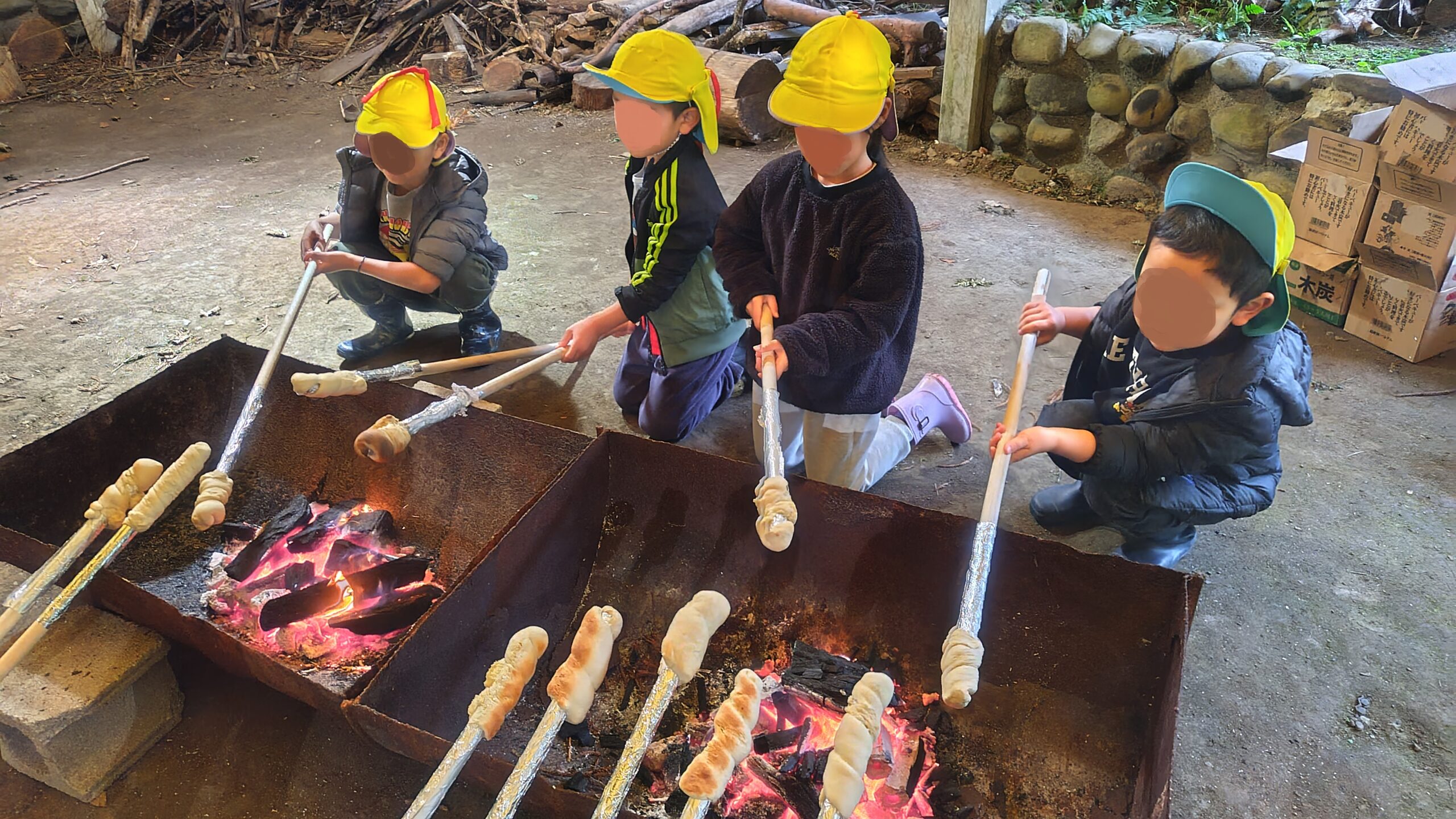 屋久島の森で炭火を使ったパン焼き体験をするあゆみの森こども園の園児たち
