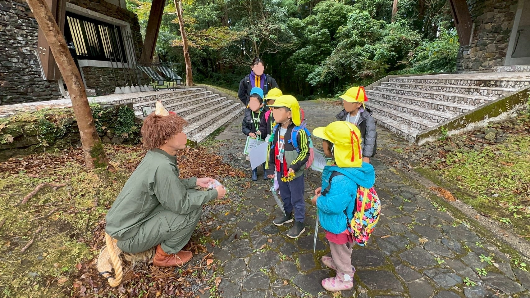 森の妖精ムッレと出会い話を聞くあゆみの森こども園の園児たち