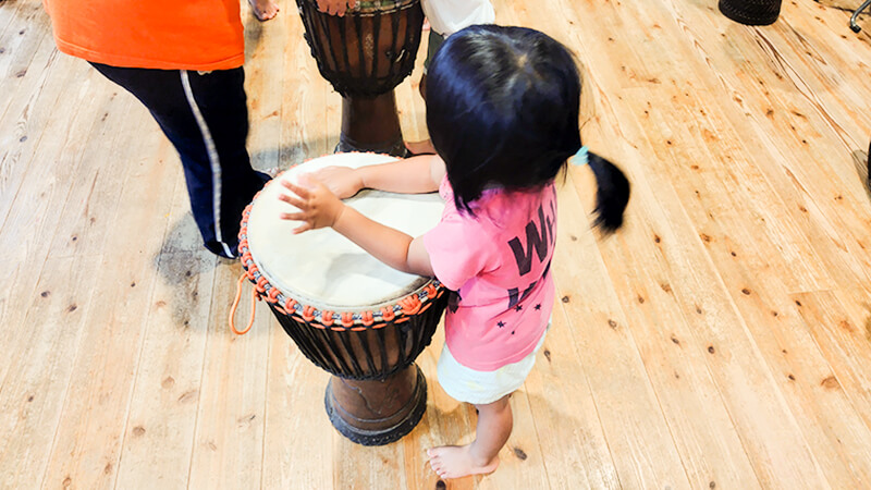 ジェンベを真剣に叩くあゆみの森こども園の女の子のリズム遊び