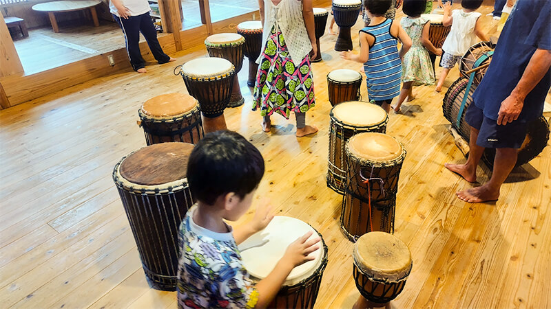 先生と一緒にジェンベの叩き方を学ぶあゆみの森こども園の子どもたち