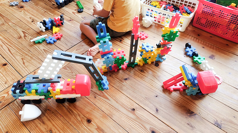 カラフルなおもちゃで遊ぶあゆみの森こども園の子どもたちの手元