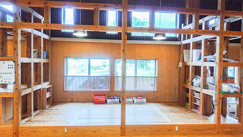 大きな窓から自然光が差し込むこども園の明るい保育室内部