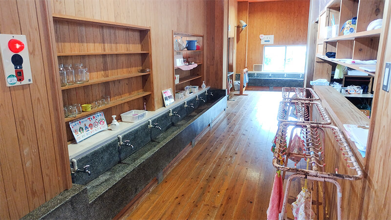 廊下に並ぶ収納棚と子どもたちの作品が飾られた園内の様子