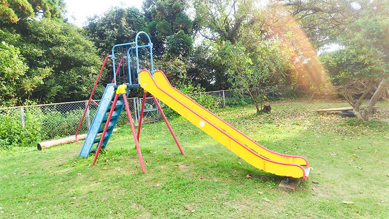 黄色い滑り台がある屋久島の自然に囲まれた園庭の遊具
