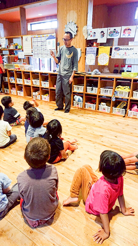 木製の園舎内で熱田園長と保護者が交流する様子